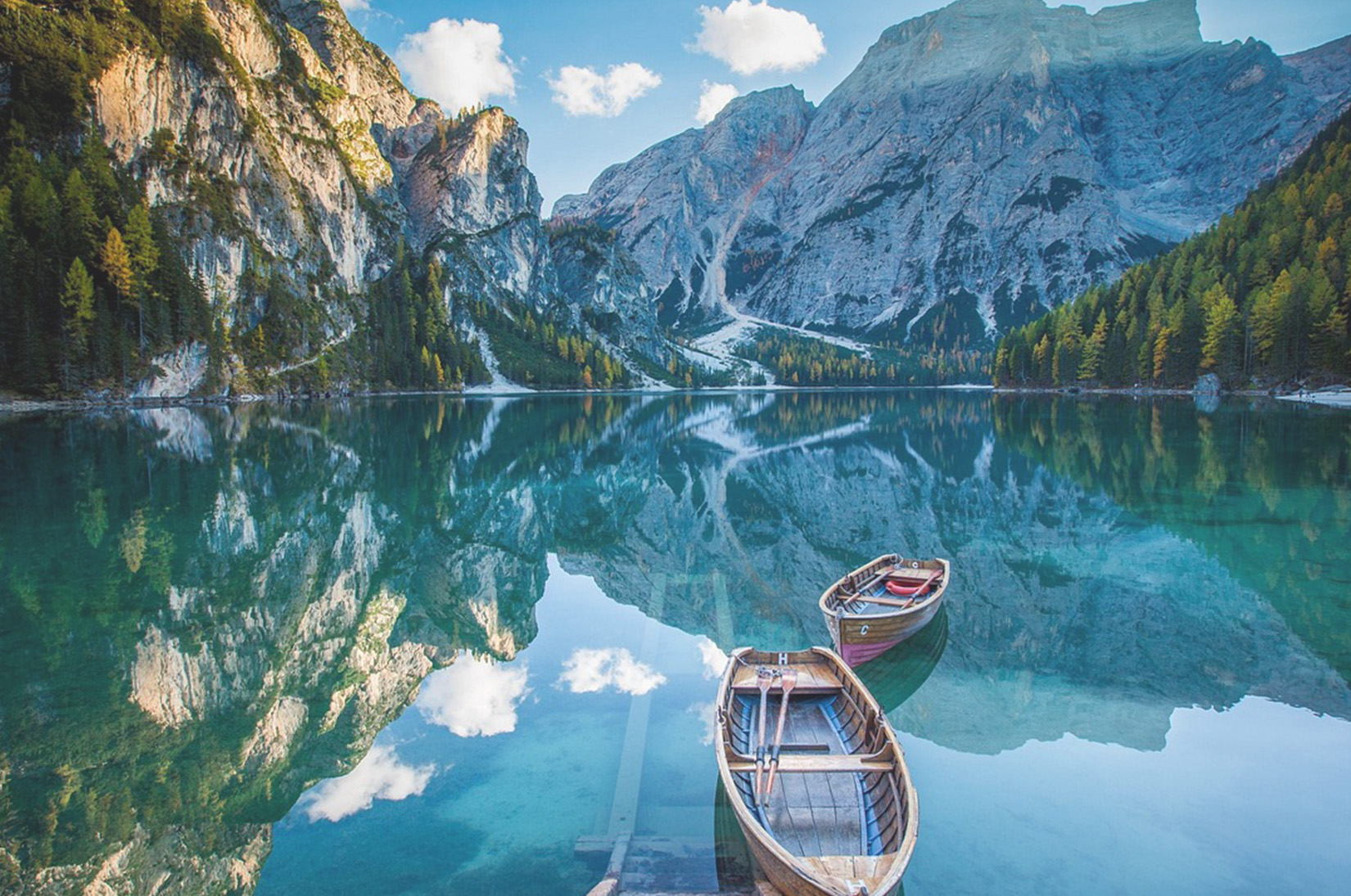 Lago di montagna con barchette in legno, armonia tra persona e natura